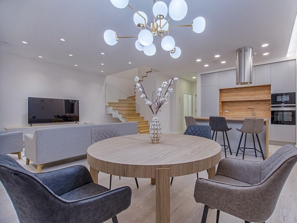 moderner, grauer Wohn-Ess-Kochbereich mit Holzakzenten